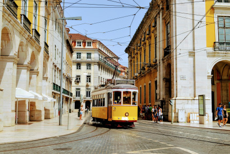 yellow-and-white-tram-on-road-during-daytime in Lisbon