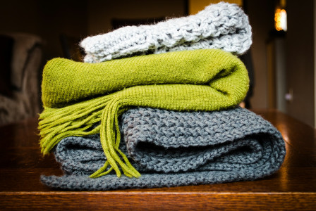 Three gray, green, and white scarf on top of table 