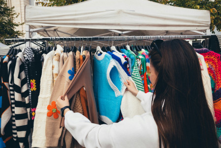Woman browsing an outdoor clothing market