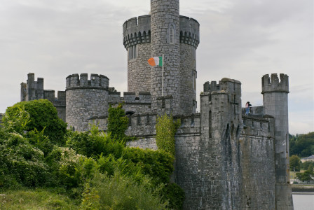 a-large-castle-sitting-on-top-of-a-lush-green-hillside