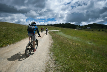 cyclists-riding-on-a-dirt-path-through-grassy-hills