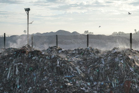 A pile of garbage sitting next to a street light photo