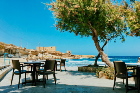 brown-wooden-table-and-chairs-on-beach-during-daytime