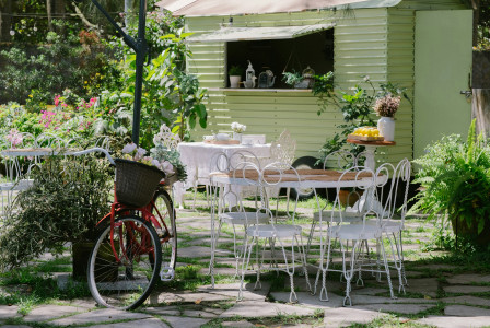 a-bicycle-is-parked-in-front-of-a-table-and-chairs
