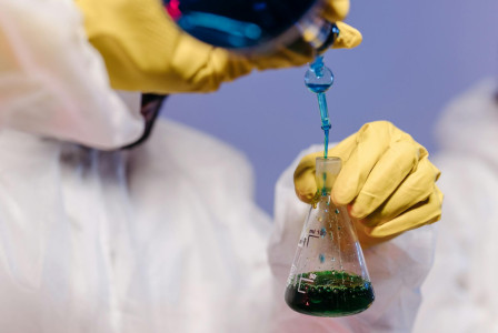 Gloved hands diluting chemicals  