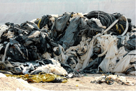 Outdoor landfill with trash and clothes gathered in piles