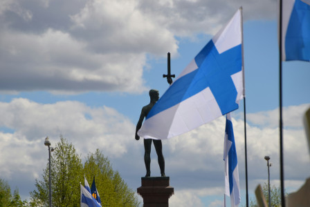 a-statue-of-a-person-holding-a-cross-and-a-flag