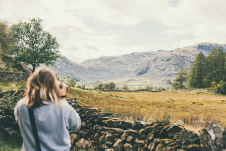 woman-taking-photo-of-brown-mountain