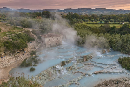 steaming-blue-thermal-springs-with-a-building-in-background