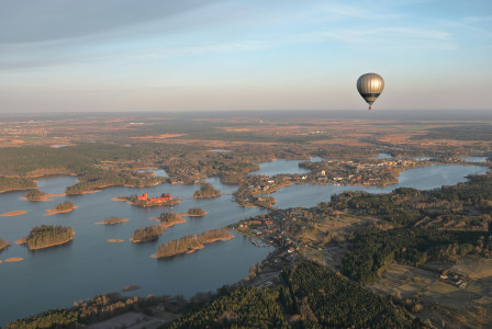 a-hot-air-balloon-flying-over-a-large-body-of-water