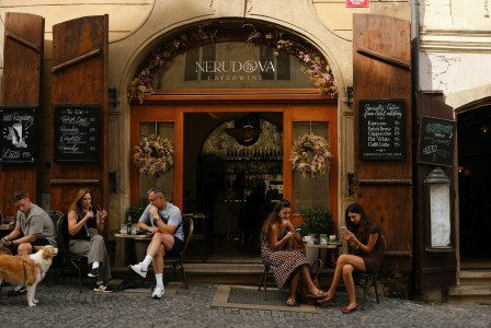 /people-sit-outside-a-restaurant-with-open-doors