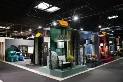 Exhibition stand showcasing interior textiles, fabrics and furniture setups at a trade fair.