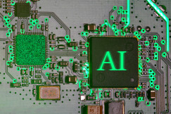 Close up image of an electronic circuit board with glowing green connections and an AI processor chip symbolising artificial intelligence and industrial digitalisation.