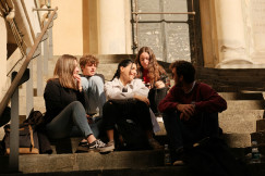 a-group-of-people-sitting-on-the-steps-of-a-building