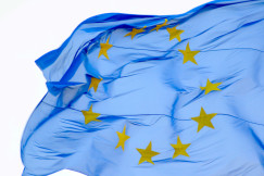 EU flag with yellow stars forming circle waving. 