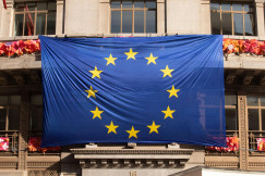 EU flag hanging on a historic building facade.