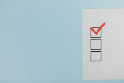 A minimalist checklist with a red checkmark on a blue background.