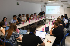 Meeting participants seated around a table with laptop.