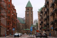 Street view leading to a church with a clock tower.