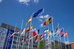 Low angle view of European Union flags on flagpoles against a blue sky.