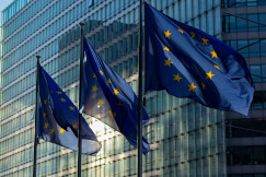 EU flags waving in front of the European Commission building.