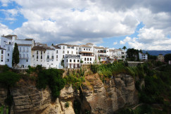 white-concrete-building-on-brown-rocky-mountain-under-white-clouds-and-blue-sky-during-daytime