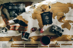 The picture presents travel items arranged on a world map, including a camera and passport.