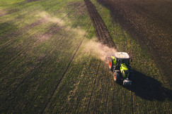 A photo presents a tractor working across a large field.