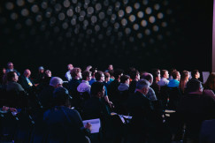 The picture presenting people during the conference looking on the stage.