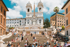 A picture presents tourists gathered on a large historic staircase.