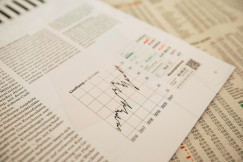Financial newspaper clipping with stock chart.