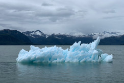 The picture presents an iceberg on the water.
