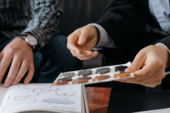 Two individuals discussing design samples and color swatches at a table, focusing on collaboration