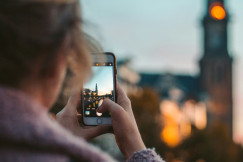 A picture presents a person taking a photo of a city landmark.