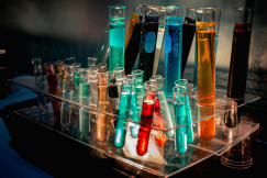 Photo presenting a laboratory test tube rack filled with colorful chemical liquids