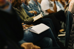 A picture presents people taking notes during an event.