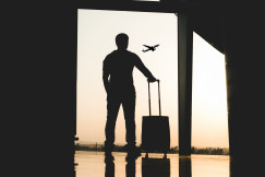 A picture presents a traveler with luggage at an airport.