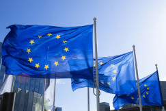 The photo presents European Union flags waving outside.