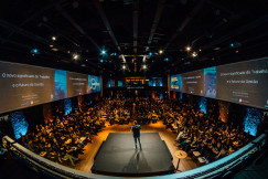 The photo presents an audience attending a conference.