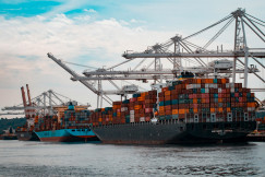 The photo presents container ships at a busy port.