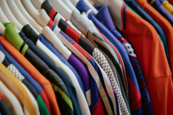 The photo presents colourful clothes on hangers.