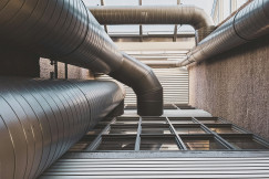 The image depicts large ventilation ducts integrated within a modern building.