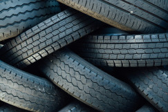 The photo presents a pile of used tires.