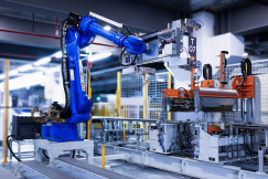 The photo presents an industrial robotic arm operating on an automated manufacturing line.