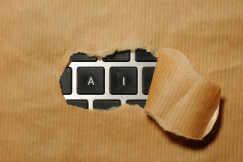 The photo presents a keyboard hidden under torn cardboard.