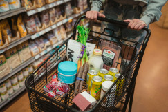 The photo presents a shopping cart filled with groceries.