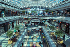 The photo presents a busy shopping mall with many people.