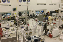 The photo presents engineers and technicians working inside a high-tech laboratory.