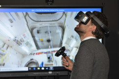 The photo presents a person using a virtual reality headset.