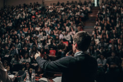 Man speaking in front of crowd.